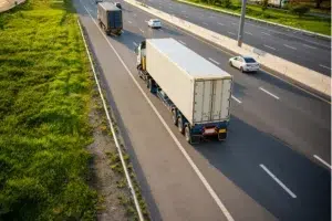 מה ההבדל בין תאוריה לרכב משא קל לבין רכב פרטי? רכב משא קל נוסע בכביש מהיר לצד כלי רכב פרטיים וממחיש את ההבדלים בדרישות הנהיגה והתאוריה