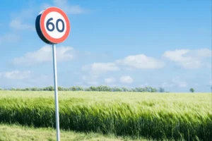 תמרור מהירות מרבית 60 קמ״ש לצד כביש פתוח כחלק מהסבר על קביעת מהירות הנסיעה המותרת